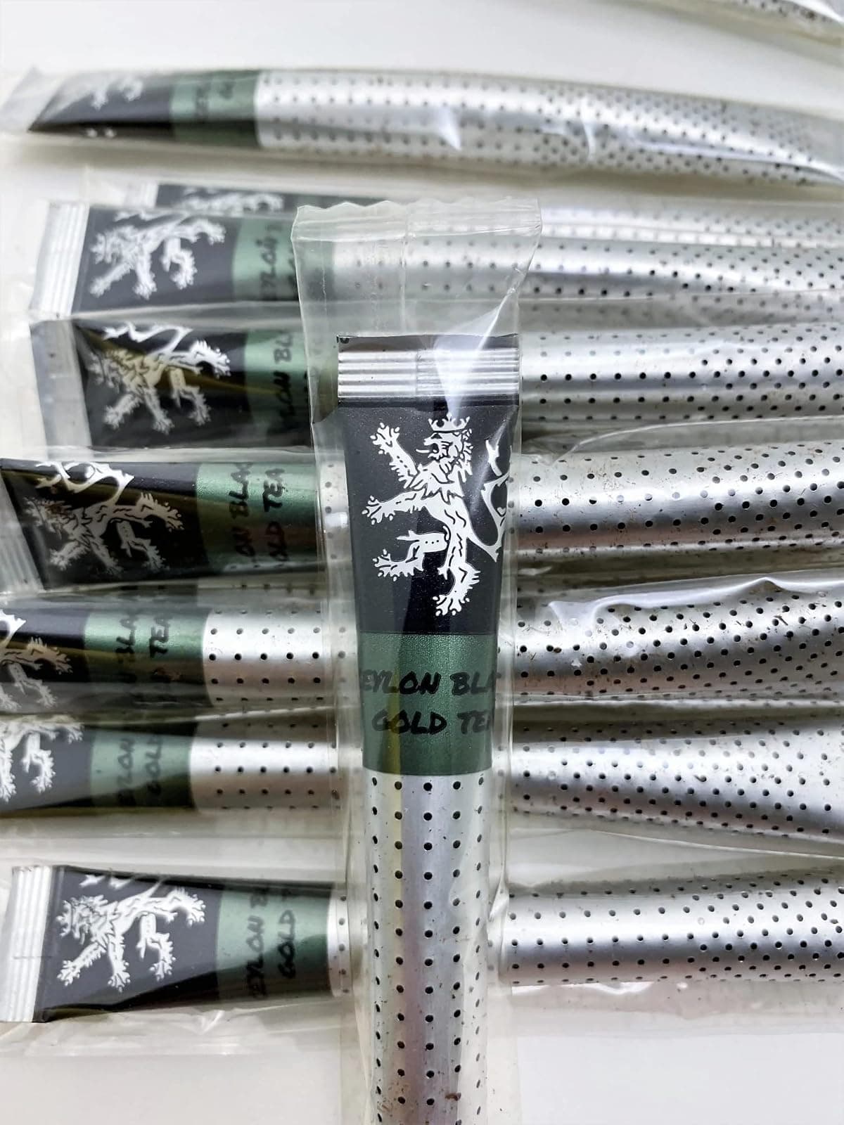 Ceylon Black Gold Tea sticks in their individual wrappers on a plain background