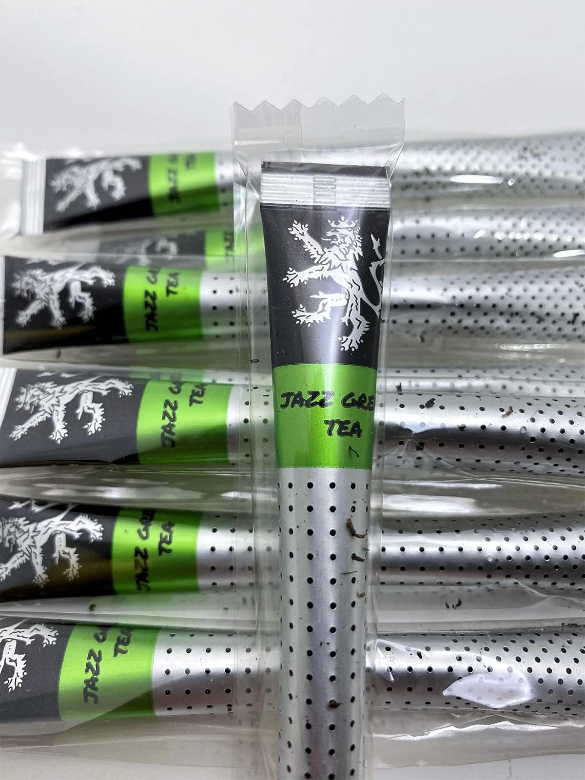Jazz Green Tea sticks in their individual wrappers on a plain background